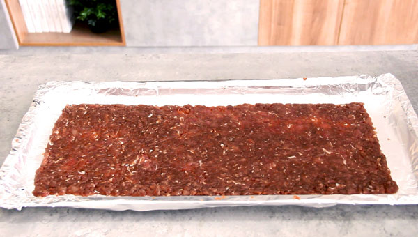 將腌制好的肉平鋪在油紙上